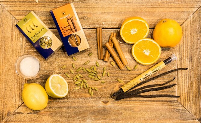 Zutaten Orangen-Sirup | © SONNENTOR Auf dem Foto sieht man ein Holzbrett mit den Zutaten die für den Orangen-Sirup benötigt werden. | © SONNENTOR