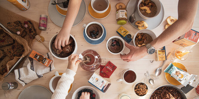 Frühstückstisch | © SONNENTOR Auf dem Foto sieht man einen vollen Frühstückstisch mit mehren Knuspermüsli Schalen und weiteren Sonnentor Produkten. | © SONNENTOR