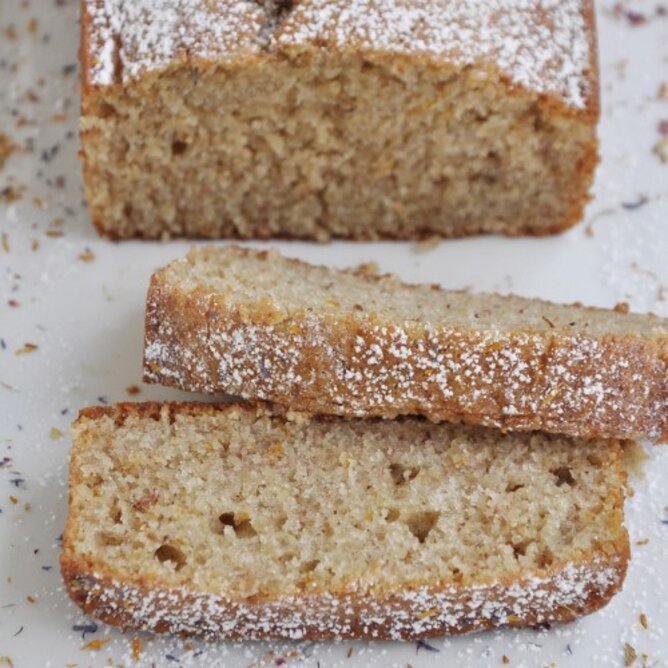 Banana Bread | © SONNENTOR Auf dem Foto ist ein aufgeschnittenes Bananenbrot zu sehen. Es ist mit Staubzucker bestreut. | © SONNENTOR